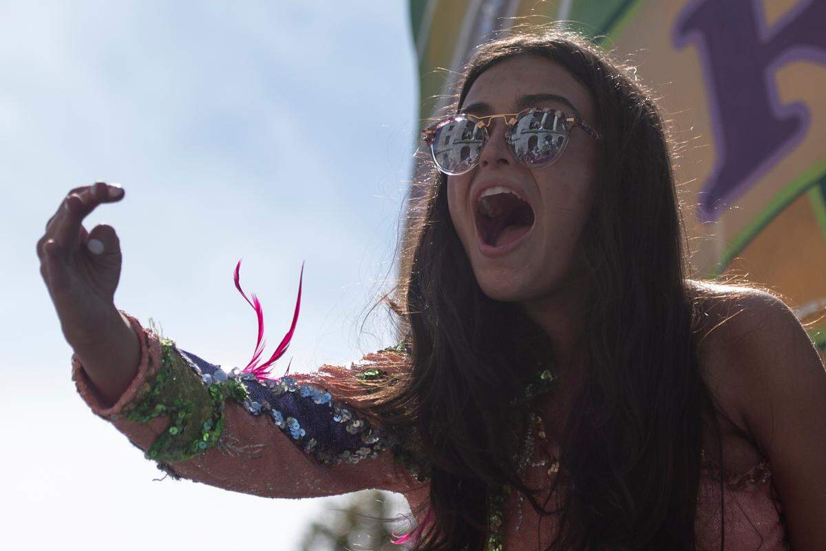 A member of GCCA royalty throws beads during the Gulf Coast Carnival Association’s Mardi Gras parade in Biloxi on Tuesday, Feb. 13, 2024.
