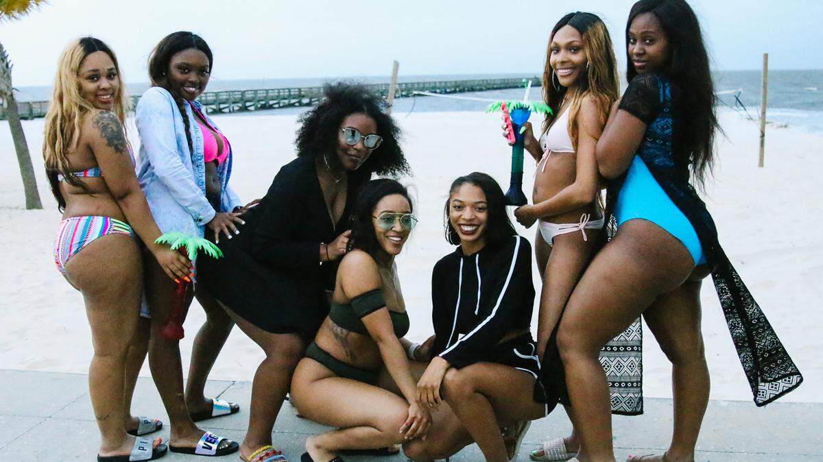 Women pose for a photo on the Biloxi beach during Black Spring Break near the Mississippi Coast Coliseum on Friday, April 13, 2018. 