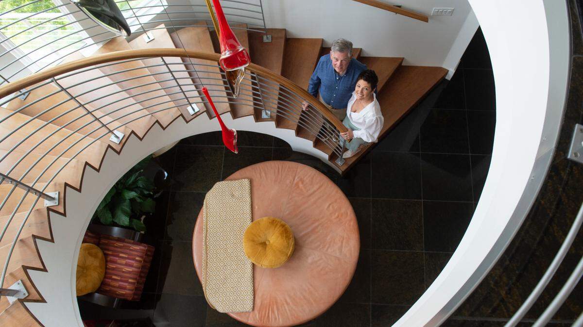 Billy and Gayla Guice pose for a photo on the spiral staircase inside their 6,000 square foot house for sale off of Rue Rivage in Ocean Springs on Friday, June 9, 2023.