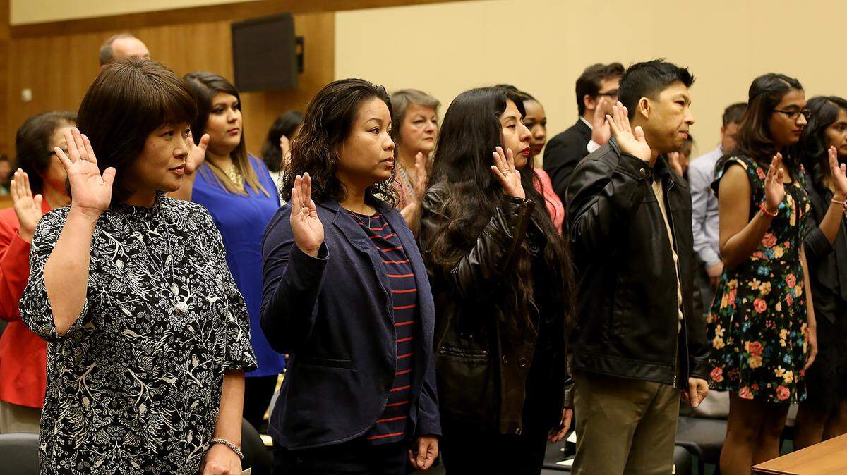 AMANDA McCOY/SUN HERALD 
 New United States citizens raise their right hand while reciting the Oath of Allegiance during a naturalization ceremony on Thursday, March 3, 2016, in Gulfport. Twenty-four individuals who became new citizens during the ceremony.