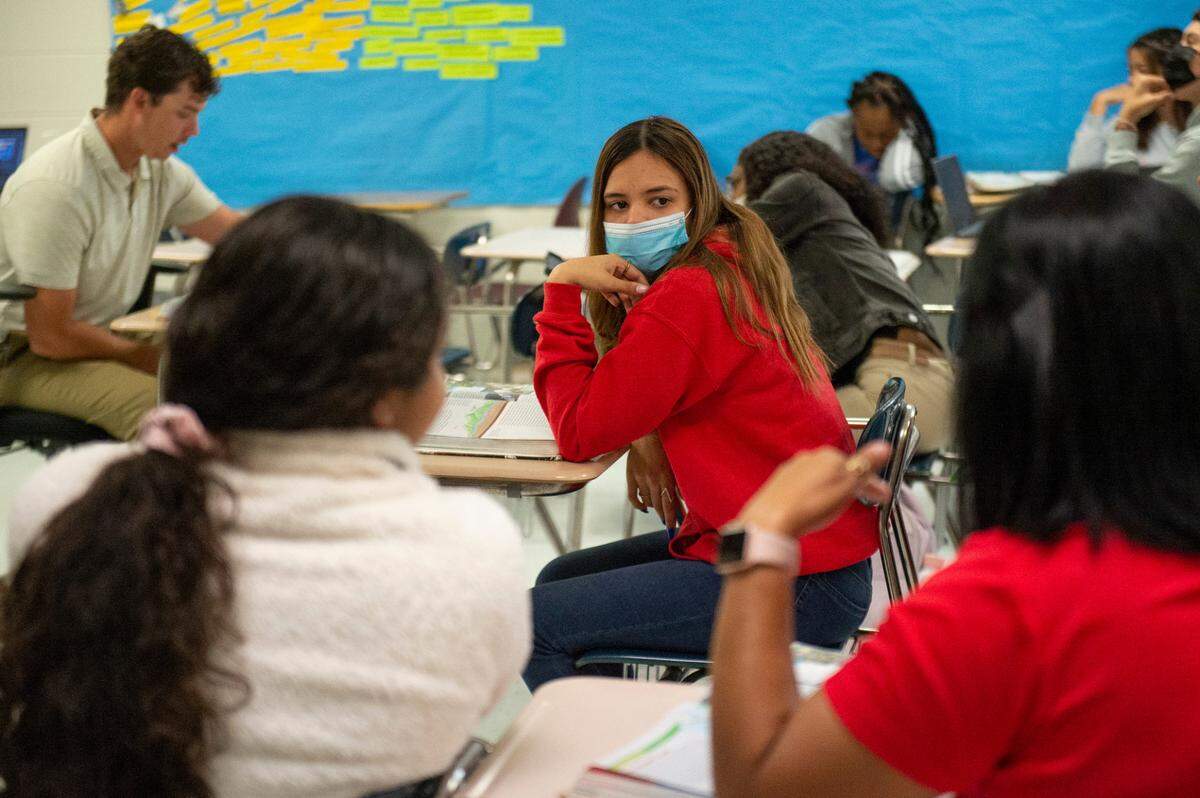 English as a second language teacher Paula Montoya, right, helps translate for her student, Natalia, center, during a history class at Pascagoula High School on Monday, Oct. 25, 2021.