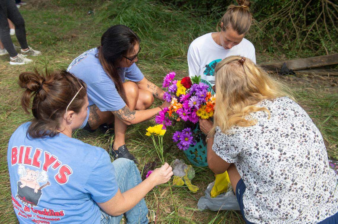 The family members of Baleigh Bowlin and Chloe Taylor put flowers into a memorial for the girls at the site of a fatal car accident that claimed the lives of both girls off of Highway 613 in Hurley on Monday, Oct. 17, 2022.