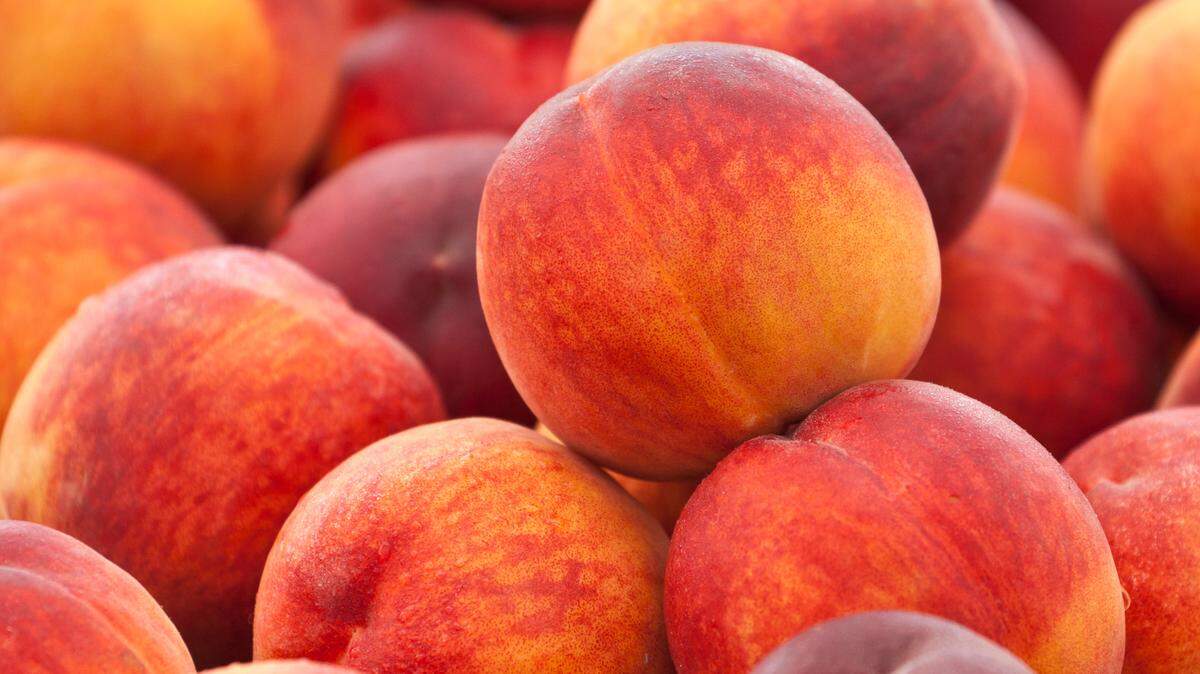 Heap of fresh organic peaches on display at a market.