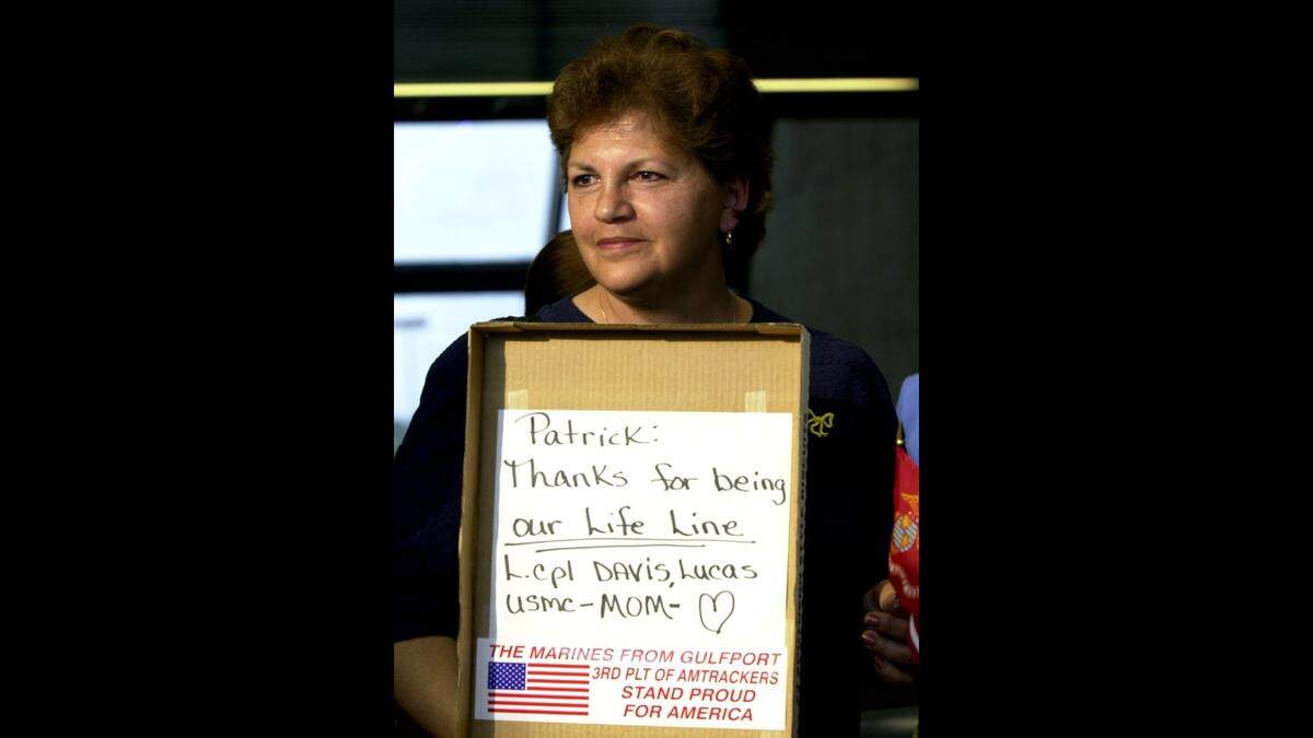 Susanne Davis of Long Beach holds a sign reading: “Patrick: Thanks for being our Life Line, Lance Cpl. Lucas Davis, U.S. Marine Corps Mom.” Peterson has been with the 4th Amphibious Assault Battalion. Davis’ son Lance Cpl. Davis is a member of the battalion.