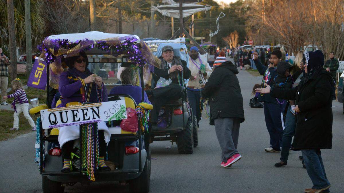 DWAYNE BREMER/SEA COAST ECHO 
 2015 Queen Nikki Moon hands out beads during the Mystic Krewe of the Seahorse parade on Monday, Feb. 8, 2016.