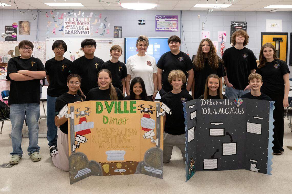 The D’Ville Dinos and the D’Iberville Diamonds pose for a photo with their teacher Angel Klobe at D’Iberville Middle School on Wednesday.