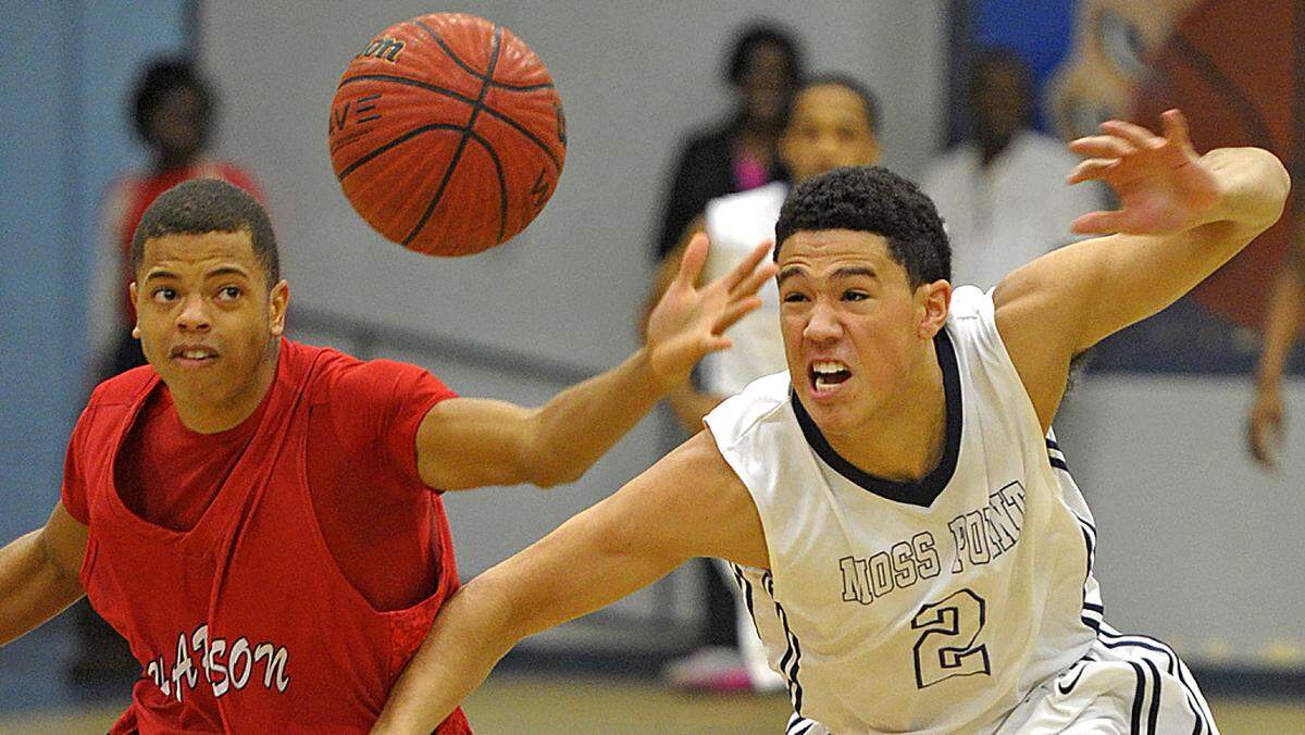 GLENN ANDREWS/SPECIAL TO THE SUN HERALD Harrison Central guard Ashton Arnold (11) and Moss Point’s Devin Booker (2) chase down a loose ball in the first quarter Friday, Dec. 13, 2013 in Moss Point.