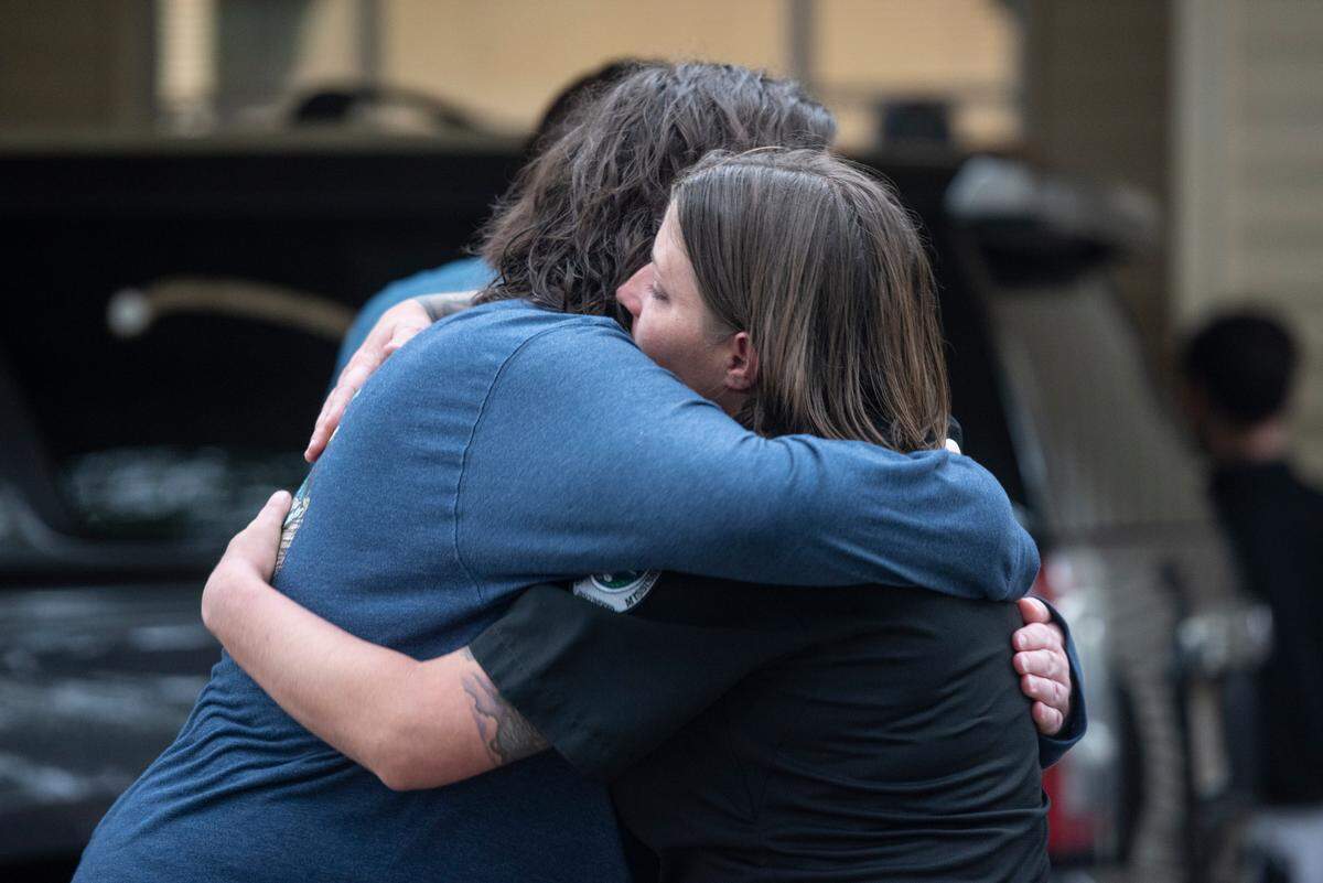 Members of law enforcement embrace and comfort each other as the body of Sgt. Steven Robin is taken to Edmond Fahey funeral home on Wednesday, Dec. 14, 2022. Robin was killed along with another officer while on duty.