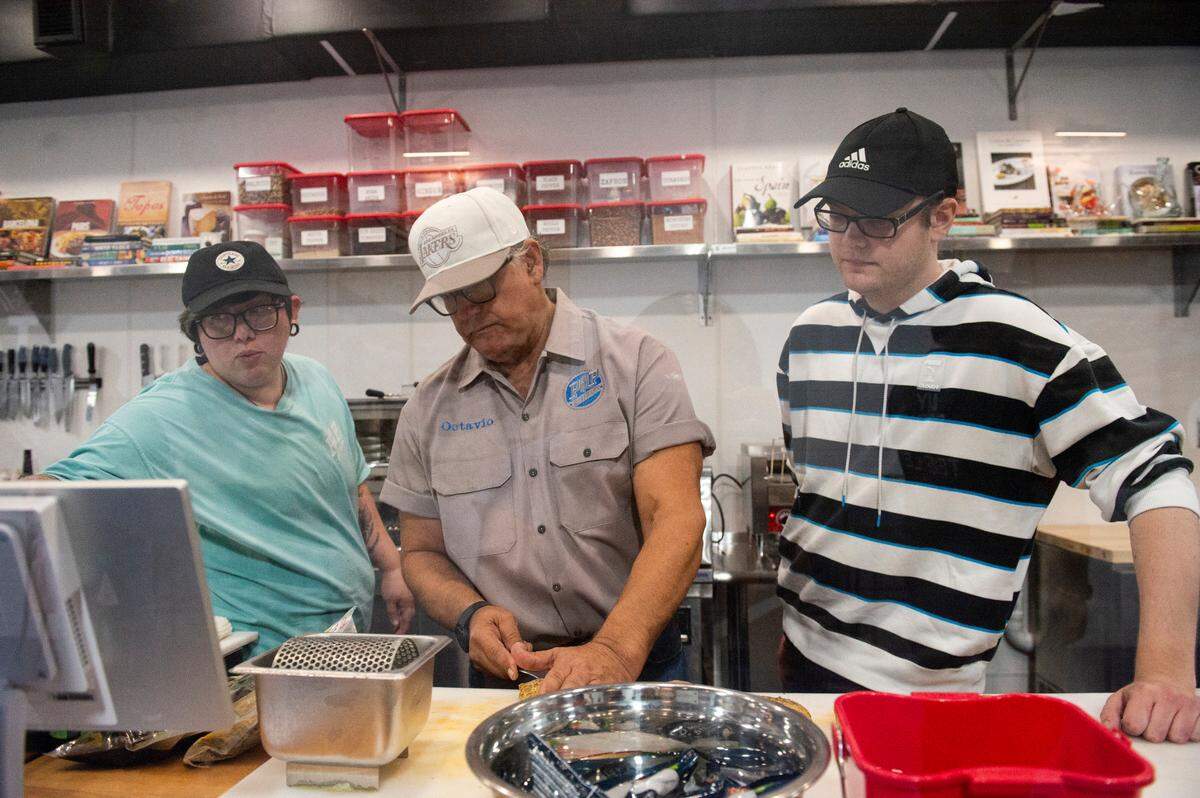 Octavio Arzola helps his employees prepare sandwiches during a tasting event at Tavi’s Salumeria in Gulfport on Thursday, Sept. 19, 2024, prior to opening to the public.