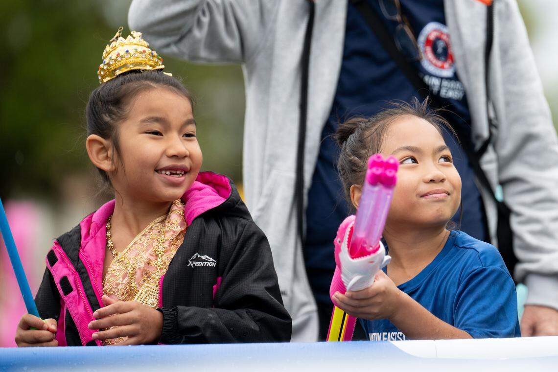Two girls shoot water as people compete in Thai water boxing during Songkran at the Wat Buddhametta Mahabaramee in Gautier on Sunday, April 19, 2026.