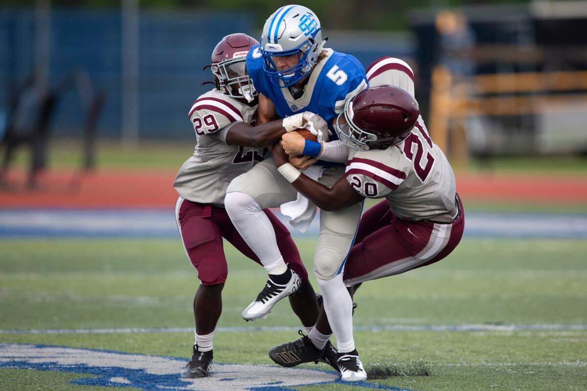 Picayune defender Amarion Tyson, left, helps sack Ocean Springs quarterback Bray Hubbard during a spring game at Greyhound Stadium in Ocean Springs on Friday, May 13, 2022.