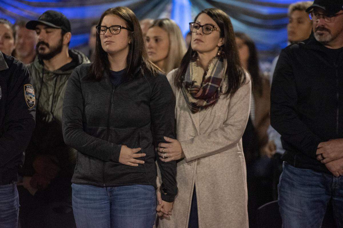 Family members of officer Branden Estorffe embrace during a candlelit vigil for Bay St. Louis Sgt. Steven Robin and officer Branden Estorffe at Tiger Stadium in Bay St. Louis on Thursday, Dec. 15, 2022. Robin and Estorffe were killed on Wednesday when a woman shot both of them.
