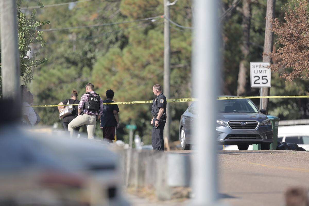 Police officers and witnesses seen outside of the scene of an officer involved shooting at a Family Dollar in Gulfport on October 6, 2022.