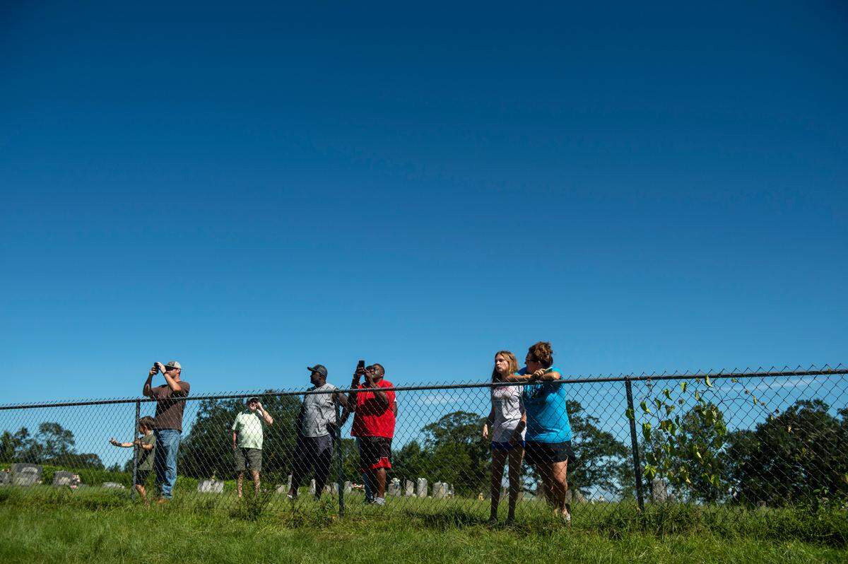 Members of the Benndale community in George County watch as workers assess damage where part of Highway 26 washed away due to Hurricane Ida on Tuesday, Aug. 31, 2021