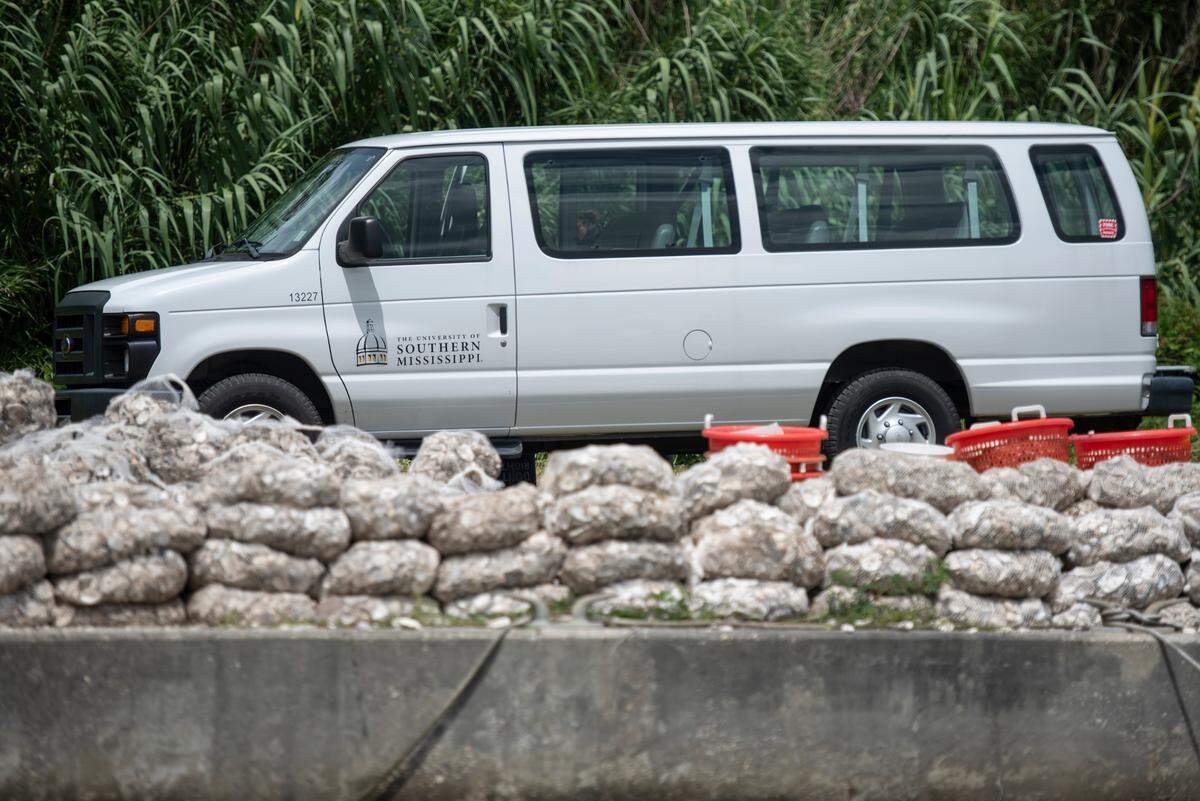 Bags of oyster shells wait to be ferried over to a project site where USM students place them as a part of a project to create a living shoreline on private property in the Back Bay of Biloxi on Tuesday, July 23, 2024. The shells were donated to the project by The Nature Conservancy Save Our Shells Program after they obtained from MGM in Las Vegas.