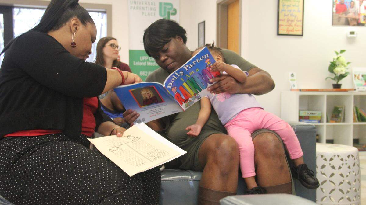 Jennifer Townsend reads to two of her children before a parenting class in the Leland Medical Clinic’s parent center.