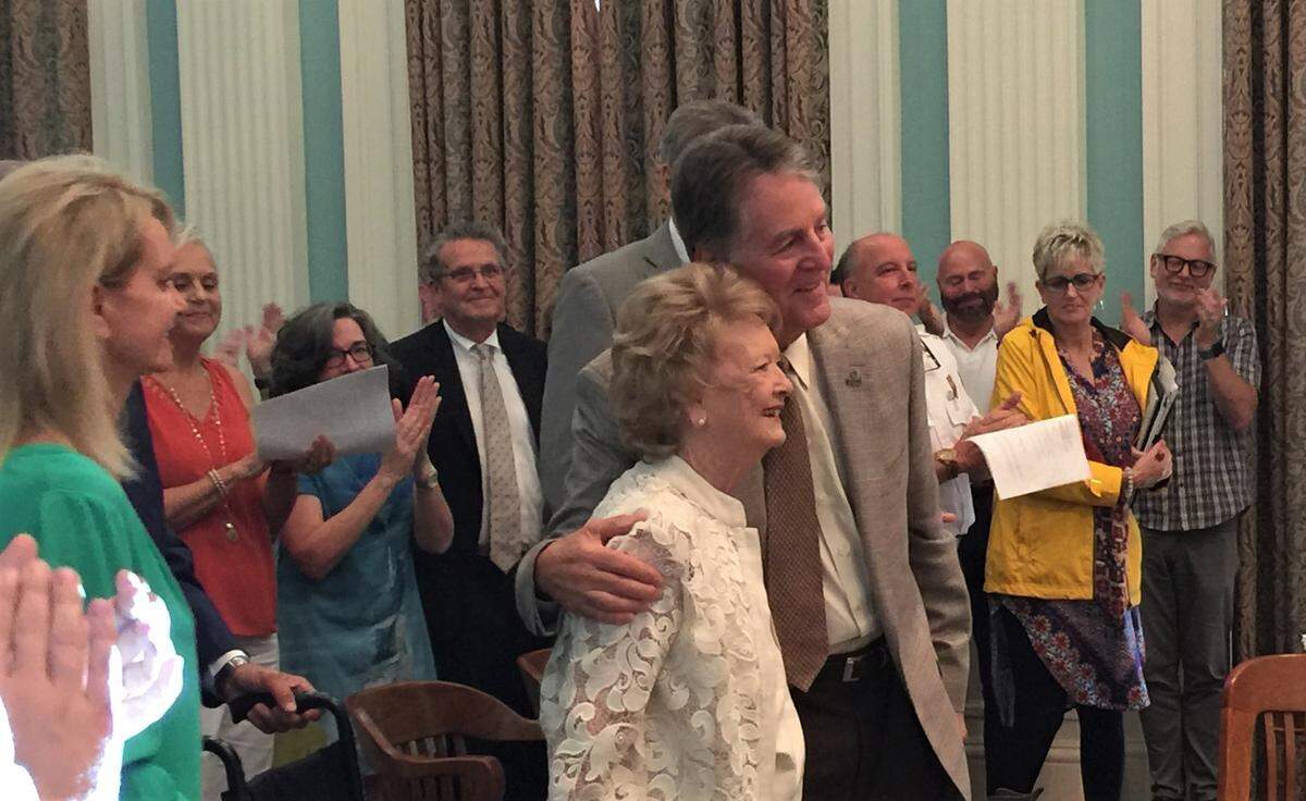 Gwen Gollotte gets a hug from Biloxi Mayor Andrew “FoFo” Gilich and a standing ovation from the crowd at Biloxi City Council after she spoke about the need to restore the Saenger Theatre again. She led the restoration of the theater in downtown Biloxi after the city purchased it in 1975.