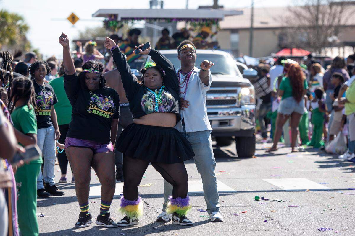 Parade attendees dance during the Jackson County Carnival Association Mardi Gras parade in Pascagoula on Saturday, March 1, 2025.