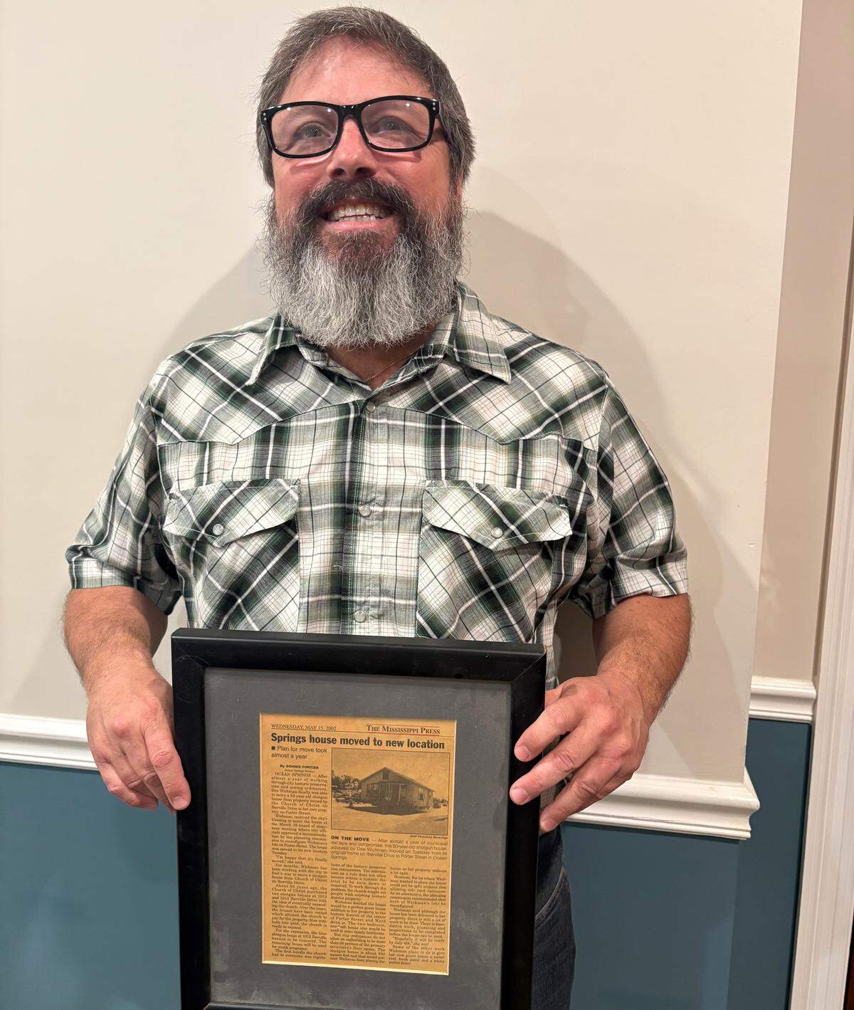 Mark J. Garriga of Ocean Springs displays a story about his mother having a house moved to their neighborhood in 2002.