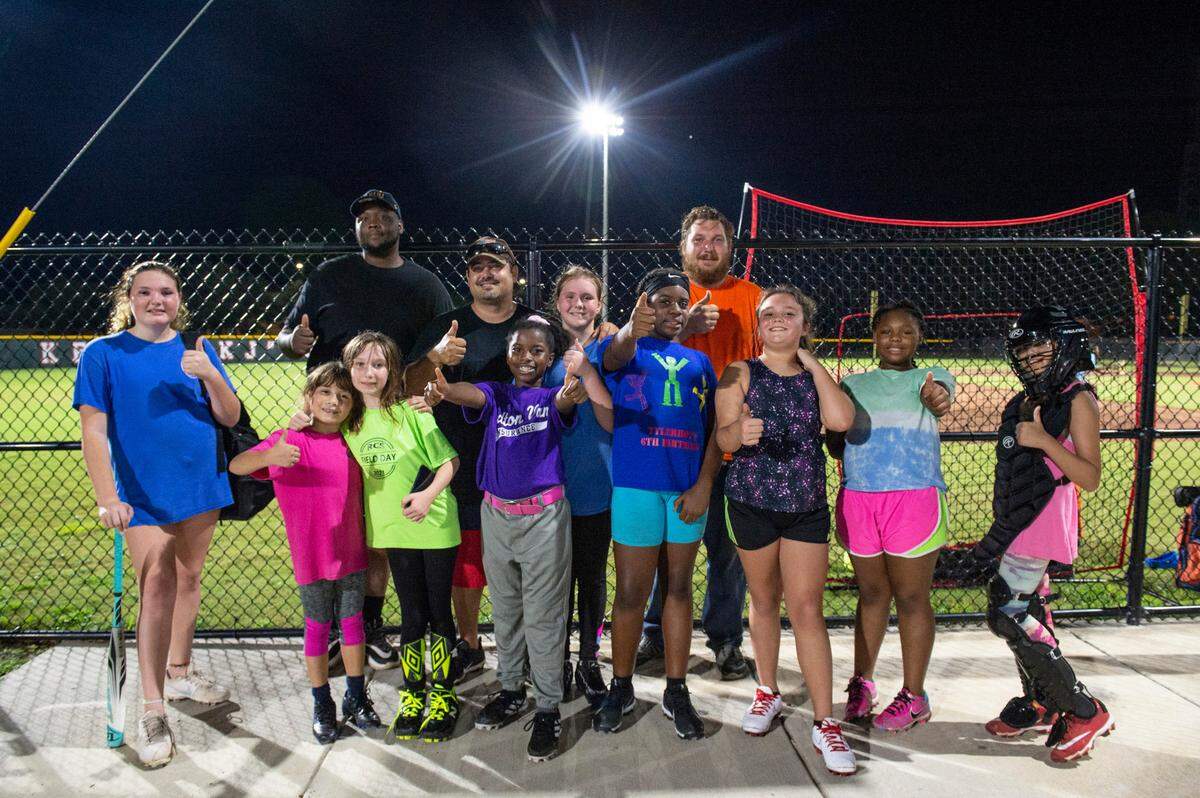 Lazaro Rovira, second row, second from left, a real estate agent, poses for a photo with the softball team that he coaches in Pascagoula on Thursday, Oct. 7, 2021.