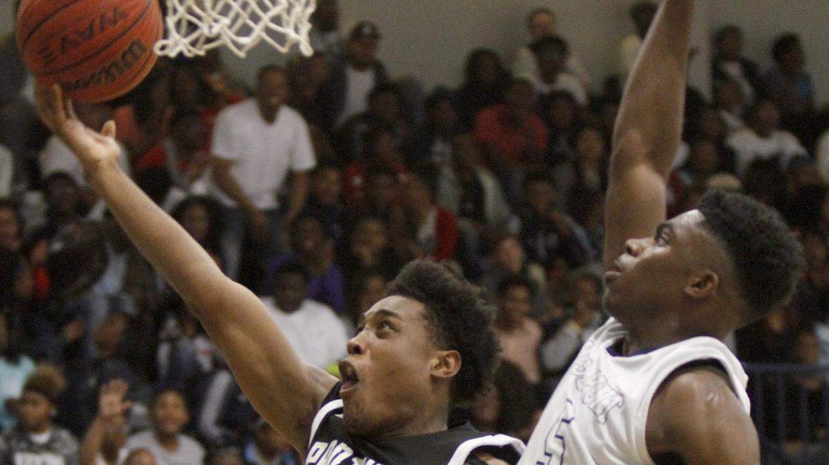 TIM ISBELL/SUN HERALD 
 Pascagoula's Jolan Moody drives the lane to score two as Moss Point's Marques Plainer goes for the block, Friday, Dec. 4, 2015.
