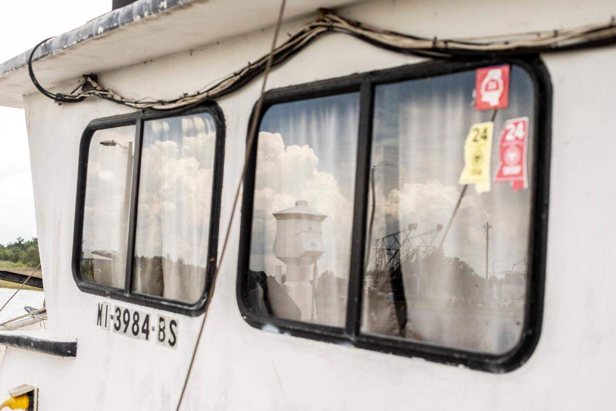 Bayou Caddy is reflected in the windows of a shrimp boat in Waveland, Mississippi on July 4, 2023.