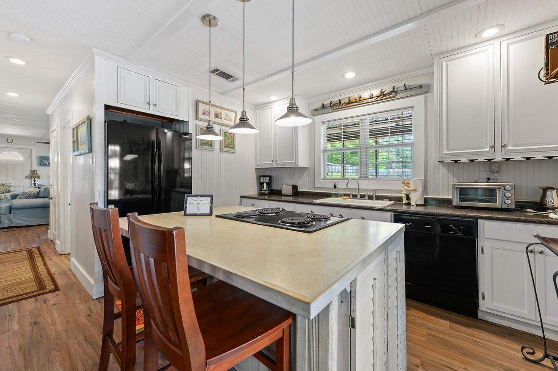 The main house at the Breezy Porches property in Waveland features an open kitchen/dining area with creative touches such as pendant lights and reclaimed kitchen shutters on the sides of the kitchen island. Owners Glenn Hood and Charles “Chuck” Underwood’s design talents are featured throughout the house and two apartments out back.