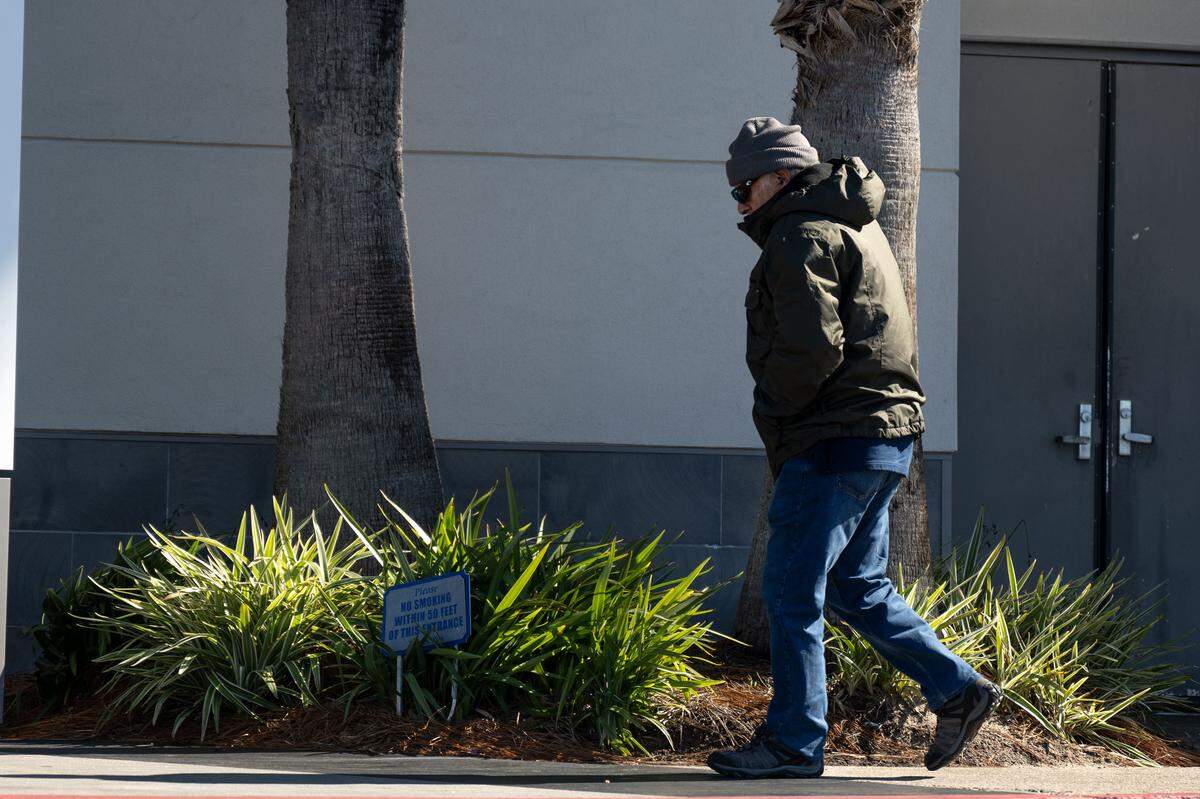 A man walks Monday outside Edgewater Mall in winter clothes.