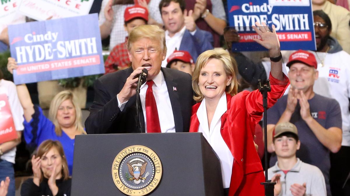 President Donald Trump speaks as Sen. Cindy Hyde-Smith waves to the crowd at the Mississippi Coast Coliseum in 2018.