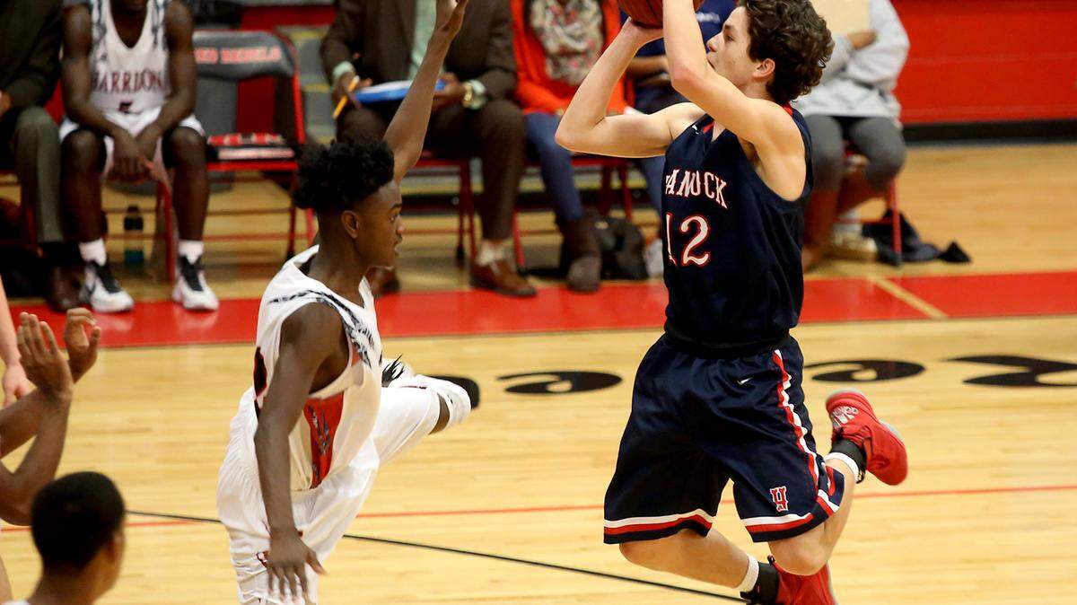 AMANDA McCOY/SUN HERALD 
 Hancock High's Colby Entriken leaps for a shot while guarded by Harrison Central's Anthony Barnett on Tuesday, January 5, 2016. Harrison Central defeated Hancock, 67-55.
