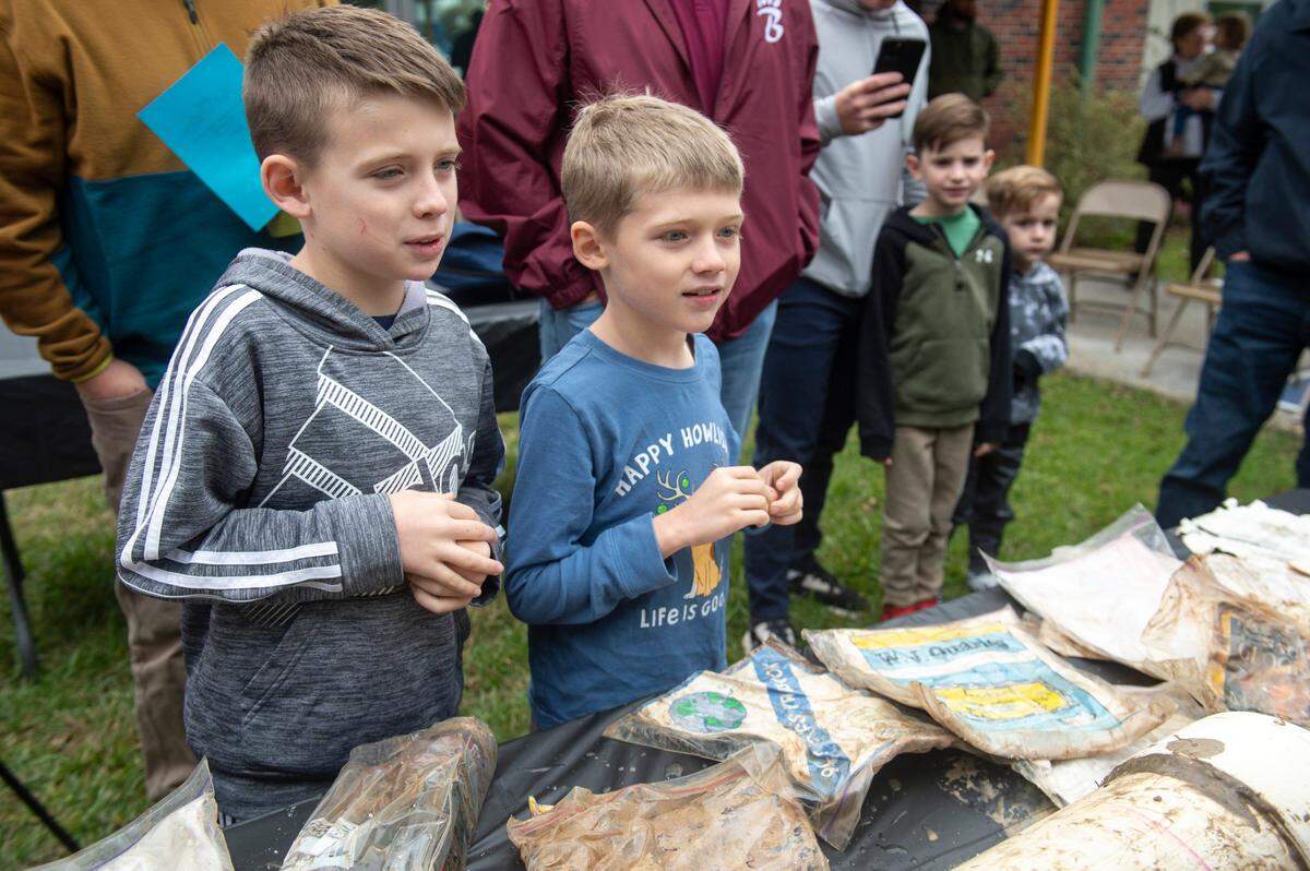 Students look on as a time capsule buried at W. J. Quarles Elementary in Long Beach in 1999 is opened at the school 25 years later on Friday, Dec. 13, 2024.