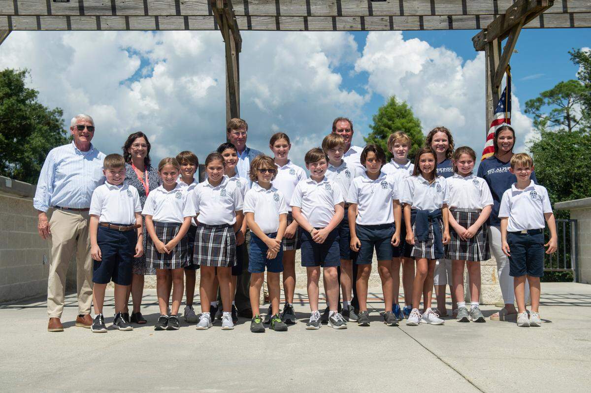 U.S. Sen. Roger Wicker, left, and Mississippi Gov. Tate Reeves, center left, pose for a picture with students from St. Alphonsus School after a speech by Wicker and Reeves on the anniversary Hurricane Katrina at Fort Maurepas Park in Ocean Springs on Monday, Aug. 29, 2022.