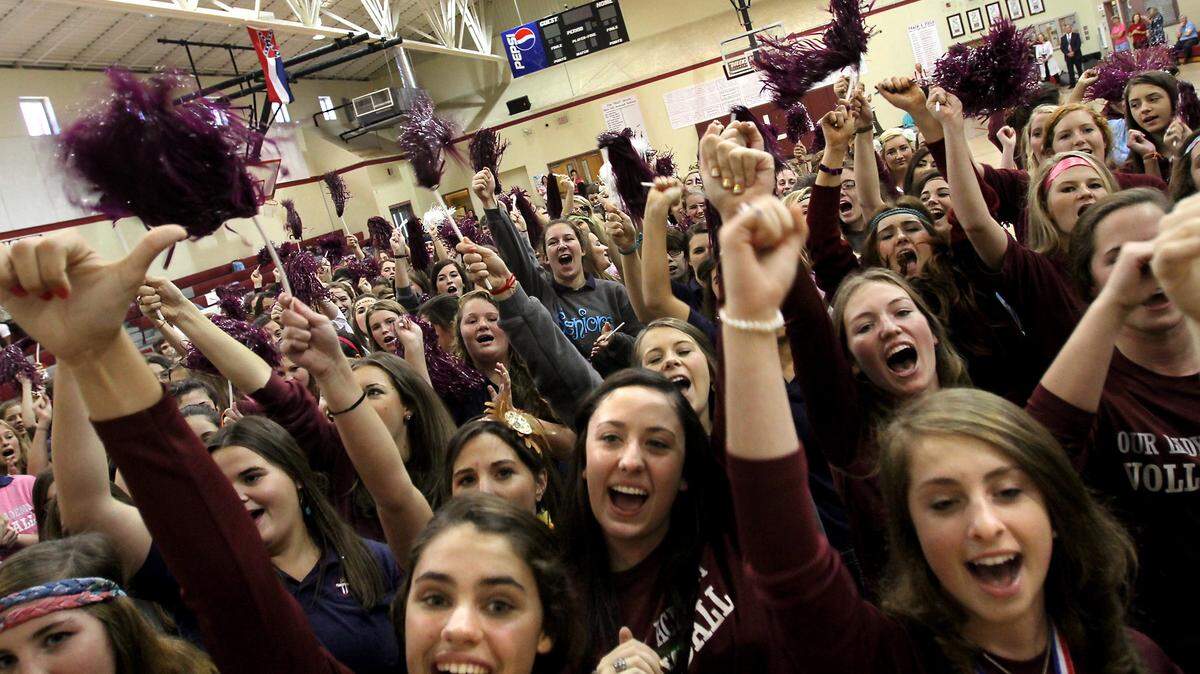 Our Lady Academy students join the state championship winning volleyball team to celebrate their win during an assembly on Tuesday, October 23, 2012.