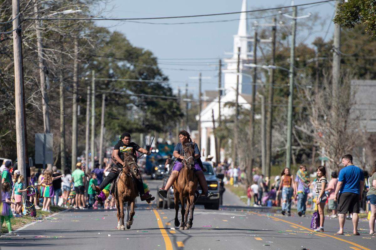 Horseback riders make their way down Pascagoula Street during the Jackson County Carnival Association Mardi Gras parade in Pascagoula on Saturday, March 1, 2025.