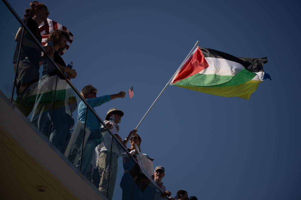 A protester waves a Palestinian flag Saturday at the No Kings rally in Gulfport.