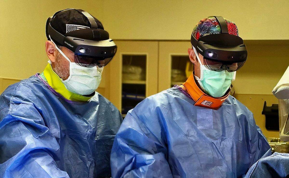 Orthopedic nurse practitioner Jay Smith, left, and orthopedic surgeon Philip Myers, right perform total hip replacement using the HipInsight system. The system is the first FDA-approved reality navigation system for hip replacement.