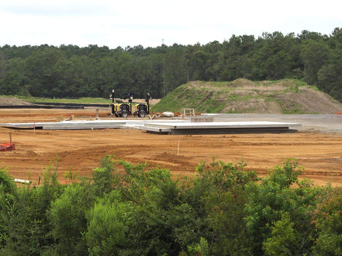 Concrete slabs are delivered to the Buc-ee’s site at exit 24 of I-10 in Mississippi and they are lifted in place by a crane to become the new travel center.