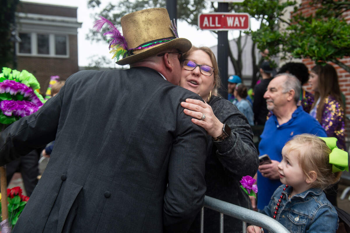A member of the Ole Biloxi Marching Club kisses a parade goer on the cheek during The Ocean Springs Elks Carnival Parade in downtown Ocean Springs on Saturday, Jan. 27, 2024.