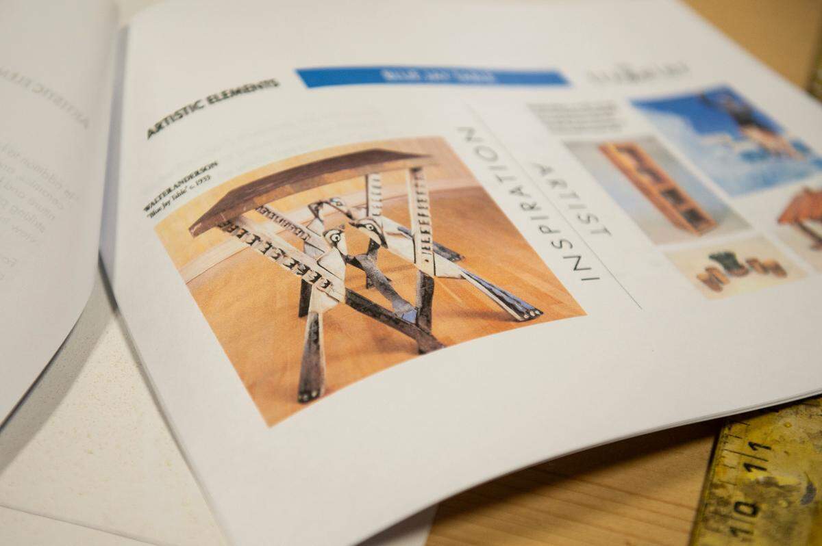 A photograph of Walter Anderson’s Blue Jay Table is shown in a pamphlet at Shane Sekul’s workshop in Ocean Springs. Sekul, a woodworker, is recreating the table for The Traveler, a new building at the Walter Anderson Museum of Art.
