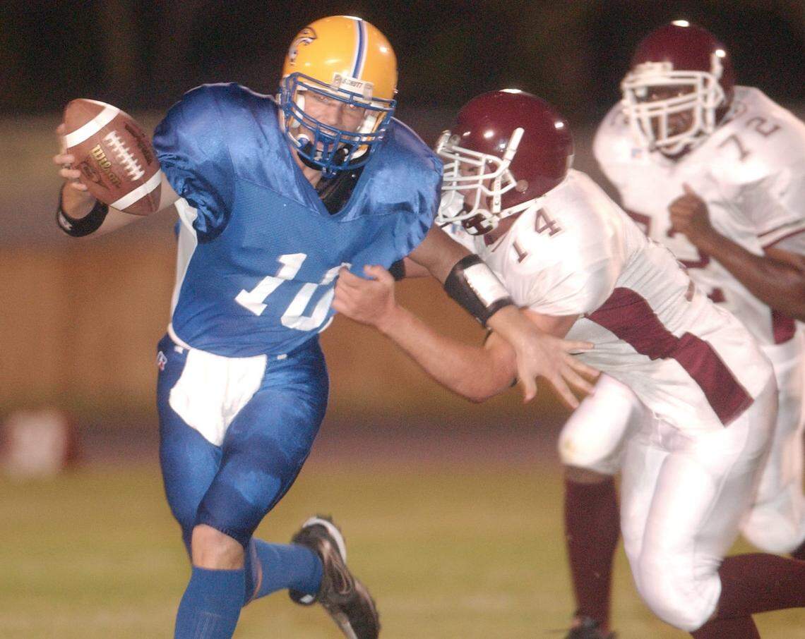 Bay High quarterback Tyler Brush (10) is hit by Long Beach linebacker Santino Davis (14) on a first-quarter carry during their game against Long Beach on Sept 26, 2005.