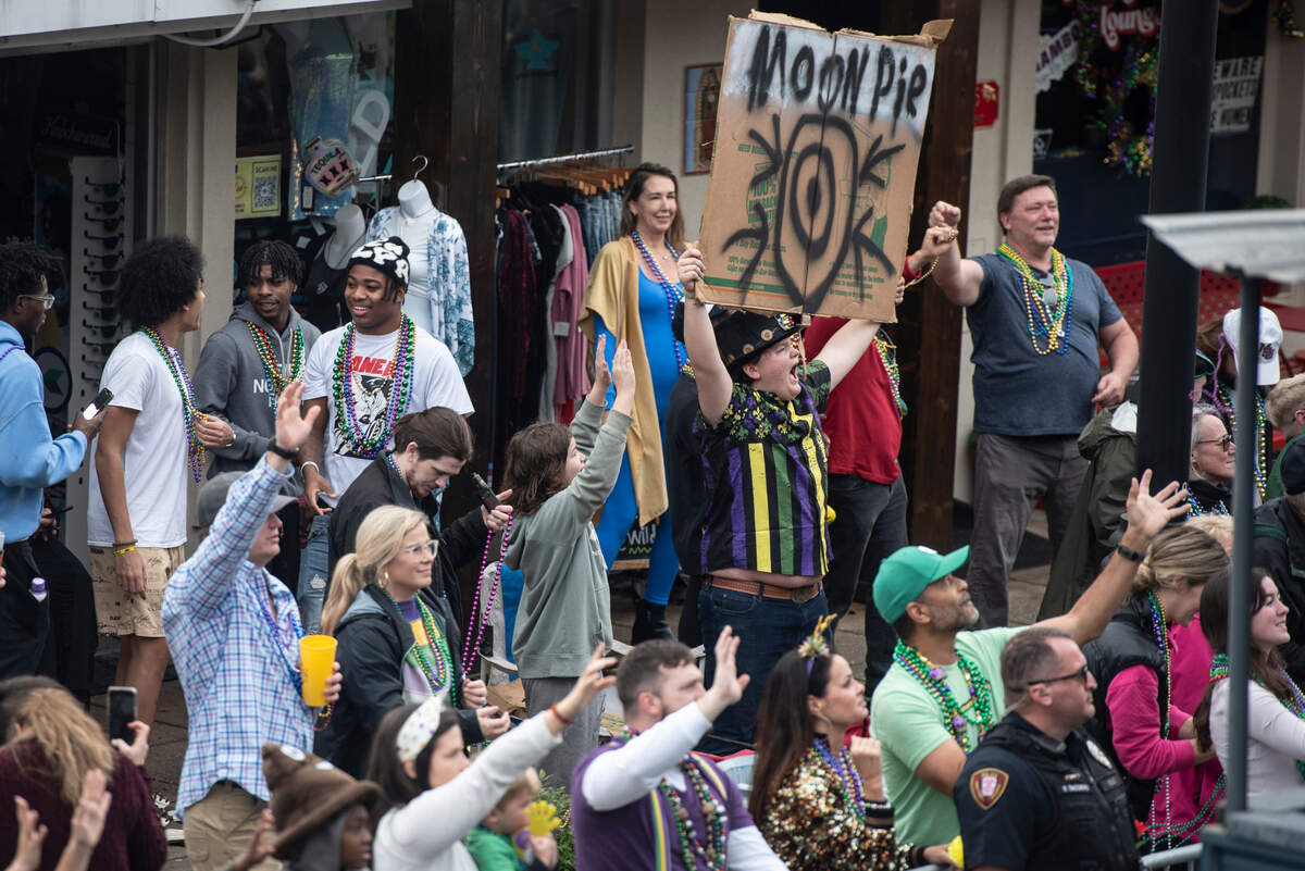 A parade attendee with a sign for Moon Pies during The Ocean Springs Elks Carnival Parade in downtown Ocean Springs on Saturday, Jan. 27, 2024.