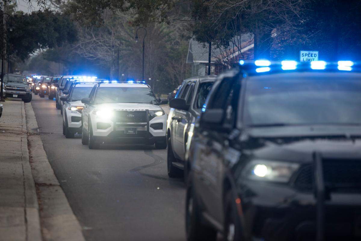 A procession of law enforcement officers drives down Main Street in Bay St. Louis escorting the body of Sgt. Steven Robin as it is taken to Edmond Fahey funeral home on Wednesday, Dec. 14, 2022. Robin was killed along with another officer while on duty.