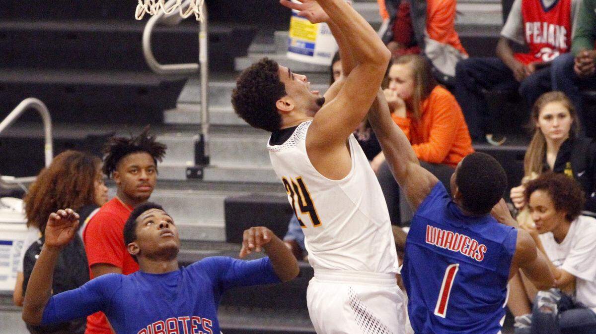 TIM ISBELL/SUN HERALD 
 D'Iberville's Evan Howard grabs an offensive rebound over Pass Christian's Jermaine Dedeaux and Aaron Whavers, Friday, Dec. 11, 2015.