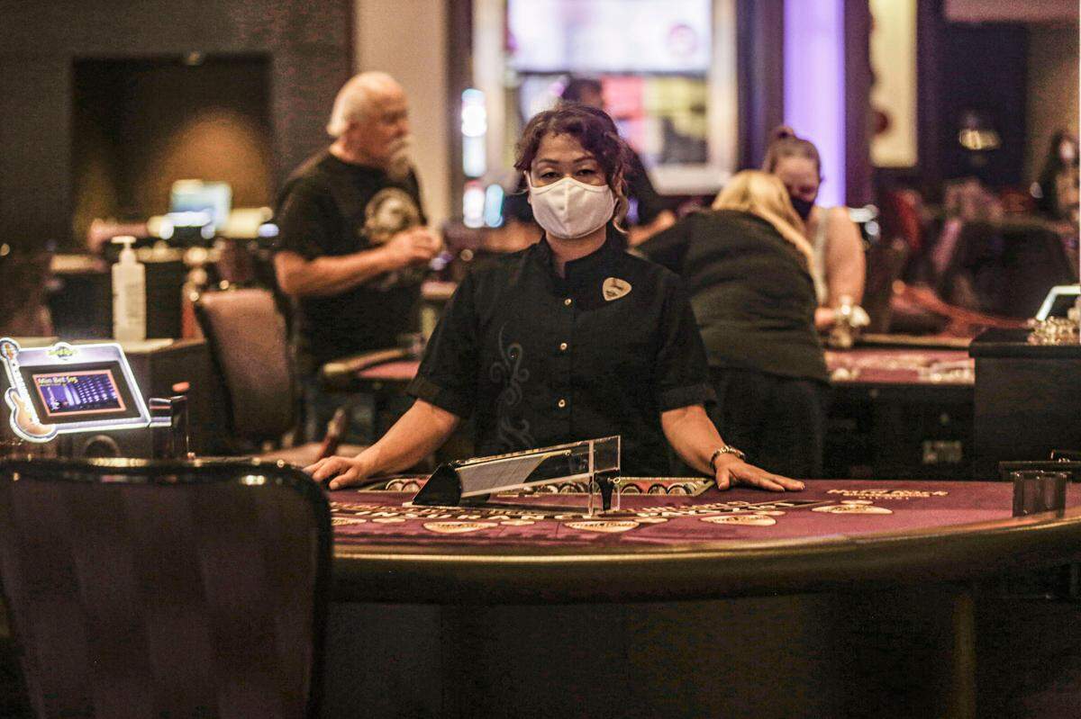 A masked Hard Rock casino worker waits for a patron at the high limit tables May 21, 2020 as the Coast casinos reopened after the coronavirus shutdown. Masks, hand sanitizer and socially-distanced slot machines became the norm to protect customers and staff.