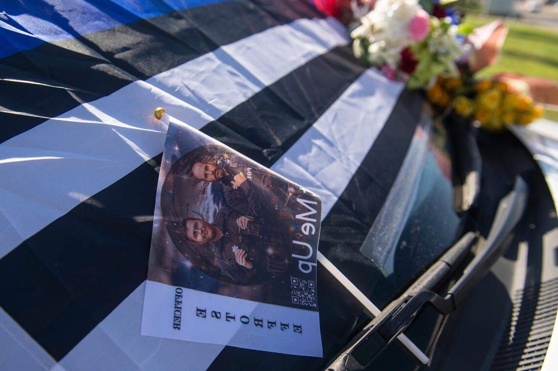 Flowers decorate a police car honoring fallen officers Steven Robin and Branden Estorffe outside City Hall in Bay St. Louis on Thursday, Dec. 15, 2022.