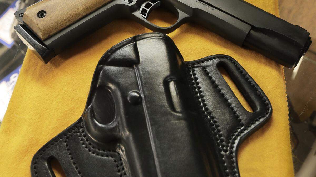 ASSOCIATED PRESSA semi-automatic handgun and a holster are displayed at a North Little Rock, Ark., gun shop in 2013. A TV channel expected to premiere in January will let shoppers make gun purchases from the comfort of the couch.
