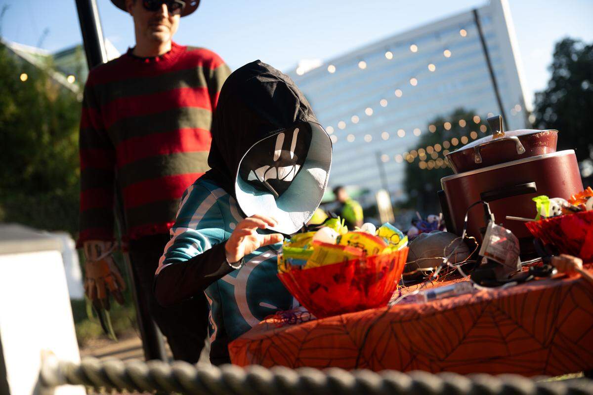 Oliver George takes candy from various chili stands during Boo On The Rue in Biloxi on Thursday, October 30, 2025.