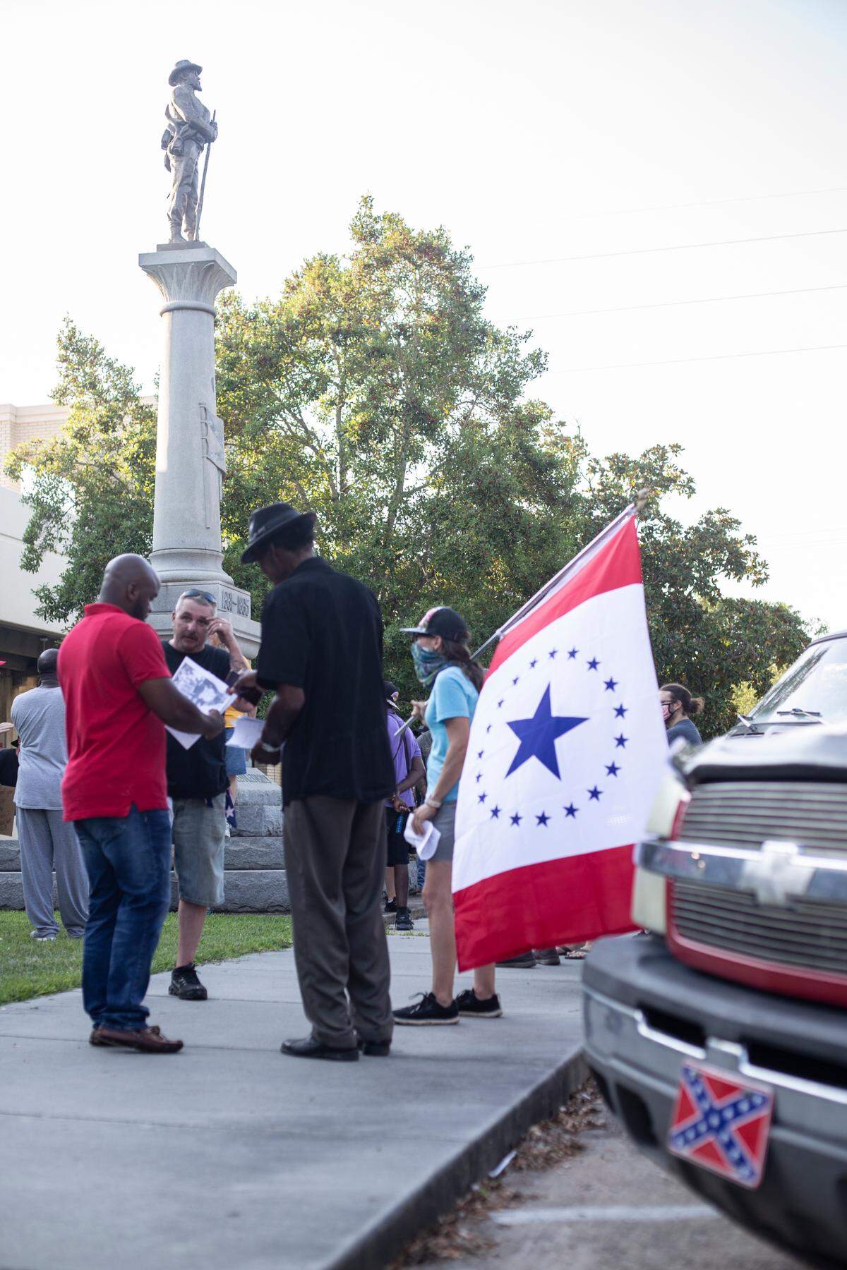 Protesters, some carrying the Stennis flag, gathered at the Gulfport Confederate Monument to rally for the Harrison County Board of Supervisors to remove it. Sons of Confederate Veterans, many on bicycles and wearing Confederate flag bandanas, counter-protested.
