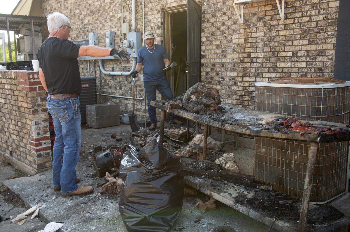 David Redwine and Austin Redwine clear debris from their family restaurant, Biloxi Country Cafe, on Tuesday, Oct. 15, 2024, after a kitchen fire the night before.