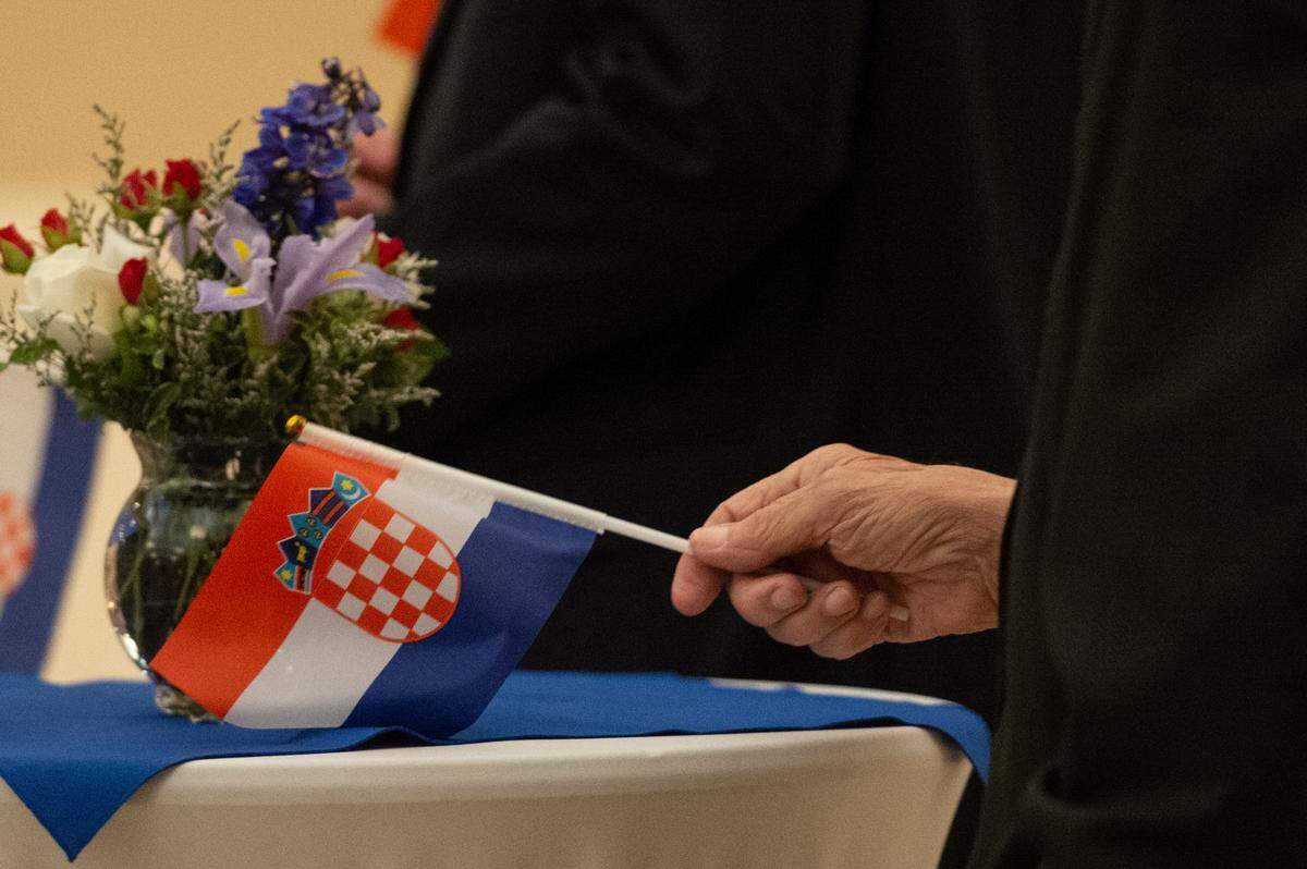A member of the Croatian American Cultural Center holds a Croatian flag during an event welcoming Croatian President Zoran Milanović at the Croatian American Cultural Center in Biloxi, Miss. on Friday, Sept. 22, 2023.